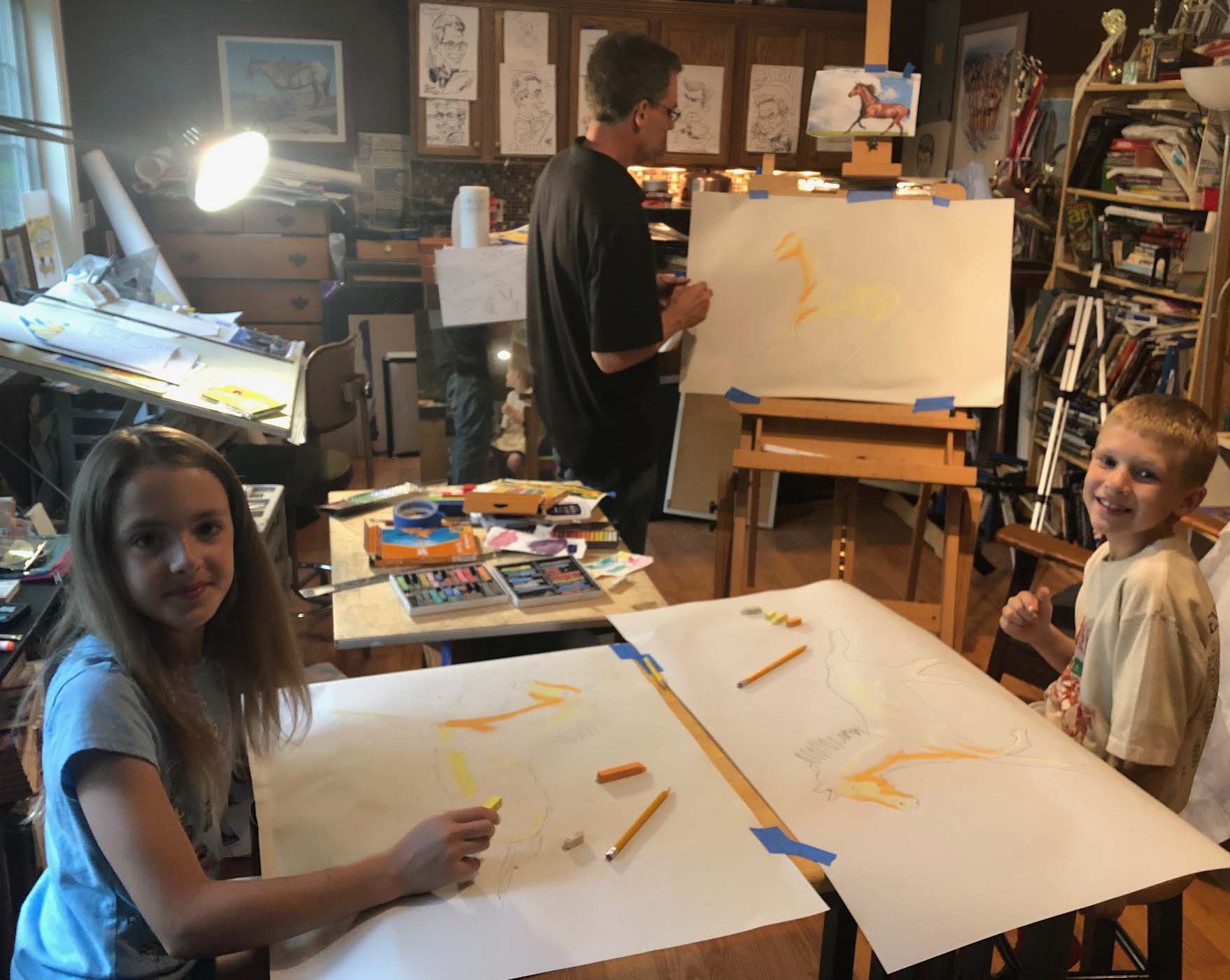 Image of two children in Bill Gustafson's art studio working with pastels
